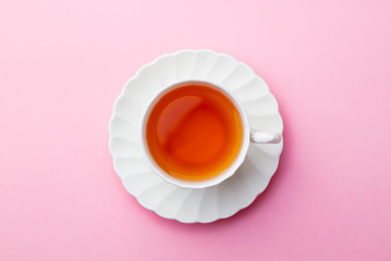 Cup of tea on pink background. Top view. Copy space.