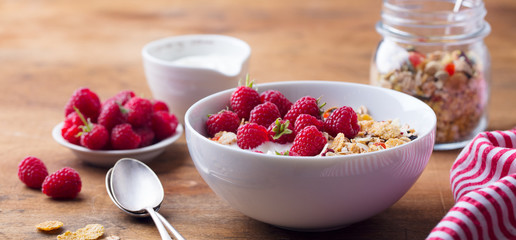 Healthy breakfast. Fresh granola, muesli with yogurt and berries on wooden background.