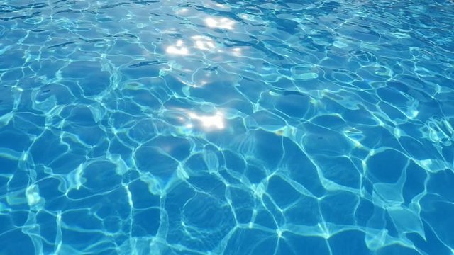 A nice view of bright light bue waters in a pool with a dazzling grid looking like diamonds changing their shapes in slo-mo