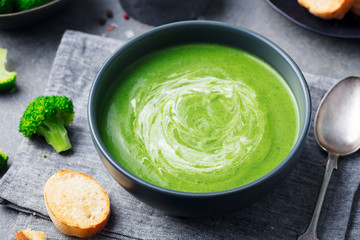 Broccoli cream soup in a bowl with toasted bread. Go green concept. Close up.