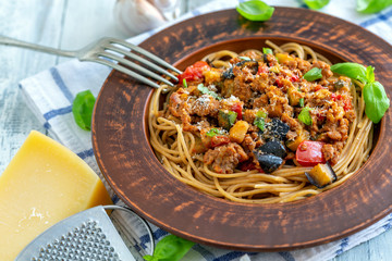 Spaghetti with bolognese sauce, vegetables and basil.