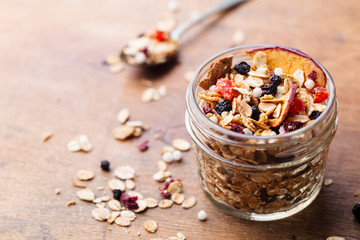 Granola, muesli in glass jar. Healthy breakfast. Organic oats with apples, berries and nuts. Copy space.