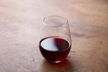 Glass of red wine on wooden background. Close up.