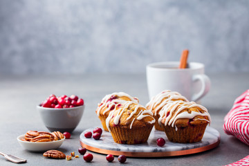 Muffins with cranberry and pecan nuts on marble board. Grey stone background. Copy space.