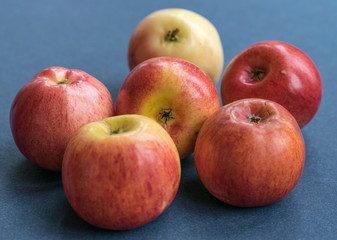 Fresh beautiful red apples on the blue backgroubd closeup.
