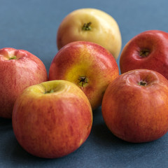 Fresh beautiful red apples on the blue backgroubd closeup.