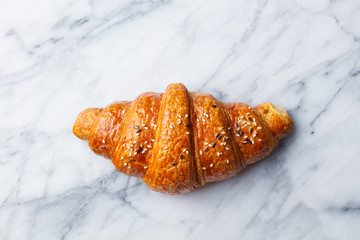 Croissant on marble table. French traditional pastry. Top view.