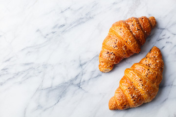 Croissants on marble background. French traditional pastry. Top view. Copy space.