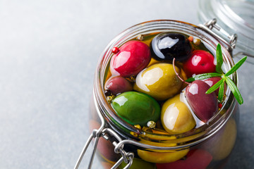 Olives assortment in glass jar with oil. Copy space. Close up.