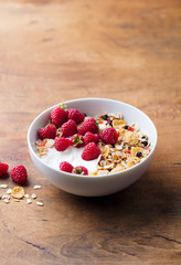 Healthy breakfast. Fresh granola, muesli with yogurt and berries on wooden background. Copy space.