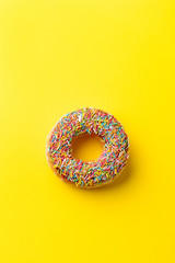 Donut on yellow background. Top view. Copy space.