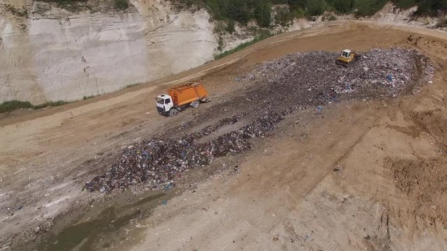 A truck unloading garbage to junkyard. Aerial shot.