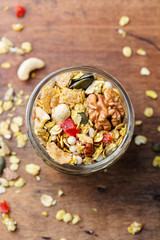 Granola, muesli in glass jar. Healthy breakfast. Organic oats with nuts, berries. Top view.