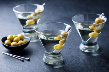Martini cocktail with green olives. Slate background.