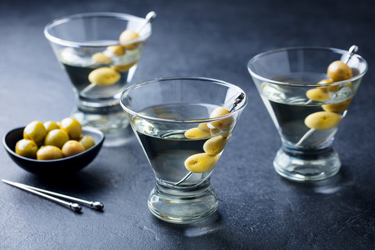 Martini cocktail with green olives. Slate background.