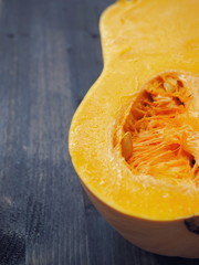 Culinary background with half of bottle shaped pumpkin close up. Selective focus on the center. Copy space for your text.