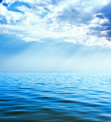 clouds with rays over blue sea