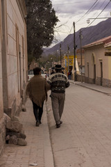 Pareja adulta con ropas tipicas caminando en una calle en Humahuaca, Jujuy, Argentina.