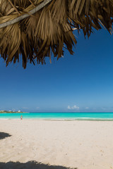 Fototapeta na wymiar Exuma, Bahamas beach scene looking out from a palapa at the blue ocean and sky
