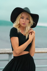Portrait of young blond girl with hat at beach
