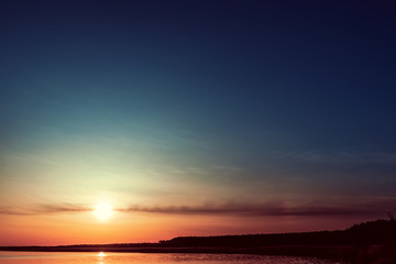 Fototapeta na wymiar good orange sunset in dark blue sky over water