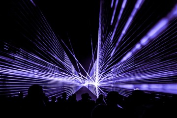 Purple laser show nightlife club stage with party people crowd. Luxury entertainment with audience...