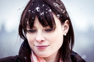 Unlucky sad woman with a bad winter depression. The young woman feels alone. She has snow in her...