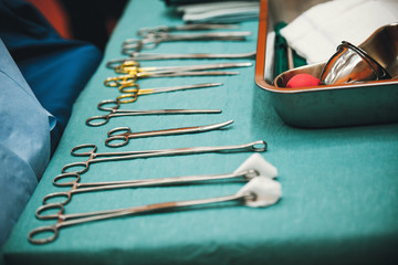 surgical instruments and tools including scalpels, forceps and tweezers arranged on a table for a...