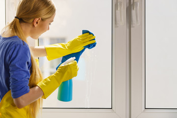 Woman cleaning window at home