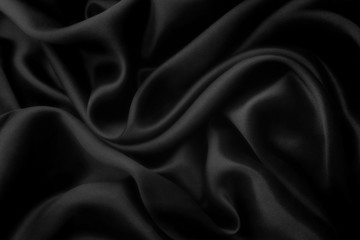 Elegant black satin silk with waves, abstract background.