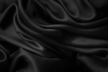 Elegant black satin silk with waves, abstract background.