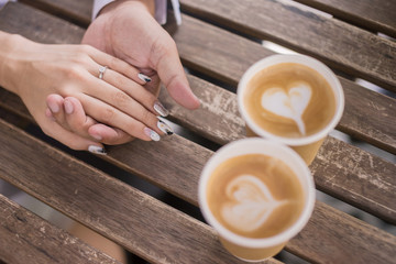 A cup of coffee in the hands of lovers