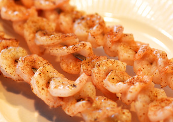 A closeup of grilled shrimp on skewers.
