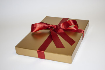 goldenes Geschenk mit rotem Band 