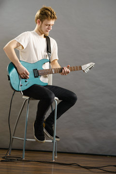 Young man playing electric guitar