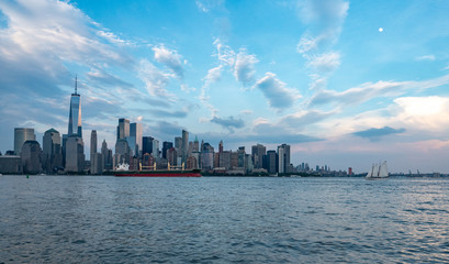 Obraz premium downtown Manhattan waterfront with moon, sailboat and cargo ship