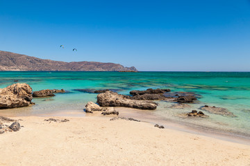 The famous beach of Elafonisi with kite surfers on background at southern Crete one of the most beautiful beaches of Greece.