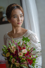 Novia con el ramo mirando por la ventana