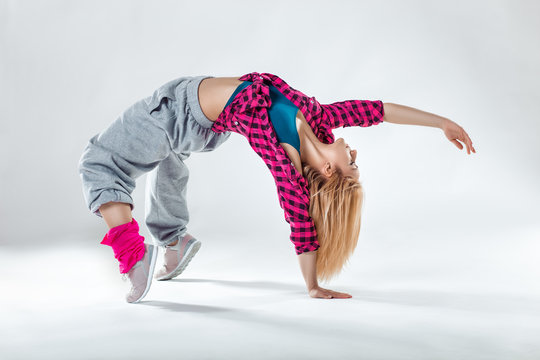Young beautiful slim girl dancing on a white studio background