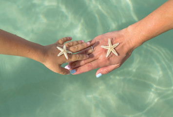 Mother and son watching starfish. Positive human emotions, feelings, joy. Funny cute child making vacations and enjoying summer.