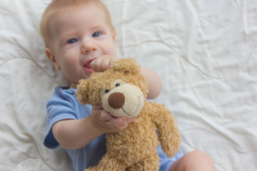 The baby with keeps a teddy bear. A toy in the hands of a baby.