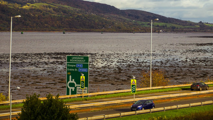 View over Langbank Roundabout road sign on the A8 and across the river Clyde.