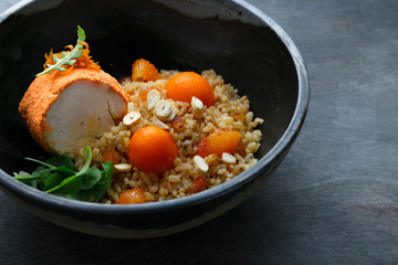 Baked turkey with bulgur, pumpkin, raisins and orange, copy space.