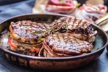 Photo sur Plexiglas Steakhouse Three grilled beef tenderloin steaks coated bacon on a frying pan