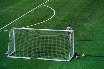 green football field with goal gate in summer
