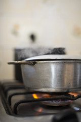 Aluminum pan on stove with flame goes in and out smoke