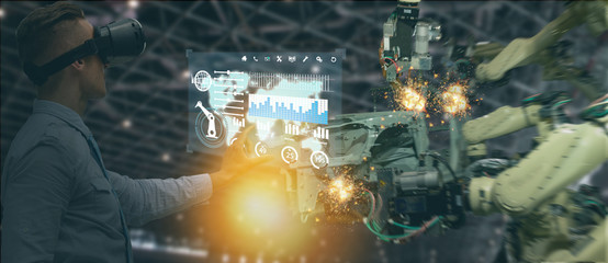 iot industry 4.0 concept,industrial engineer(blurred) using smart glasses with augmented mixed with virtual reality technology to monitoring machine in real time.Smart factory use Automation robot arm