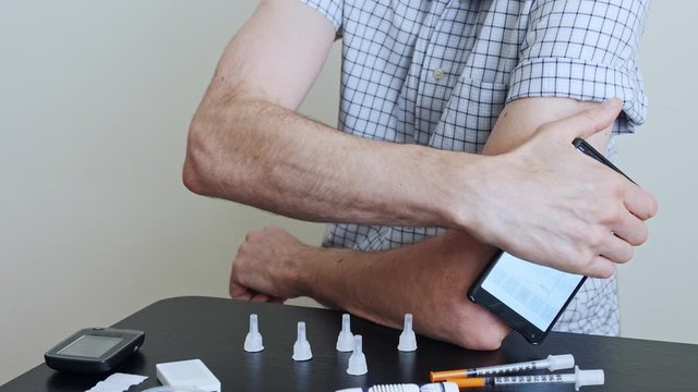 A man hands brings to the hand the smartphone for measuring glucose in the blood