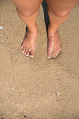 Feet on sandy beach