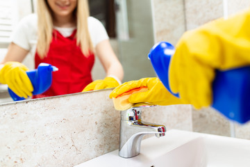 Young and happy woman cleaning house bathroom